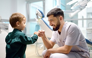 Dentist fist-bumping young patient