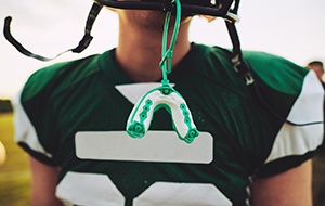 Child in sports gear with custom mouthguard in Jacksonville