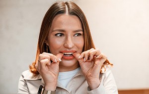 Patient putting on clear aligner in treatment room