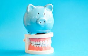 A piggy bank standing on top of model dentures