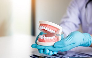 Dentist holding full dentures in hand